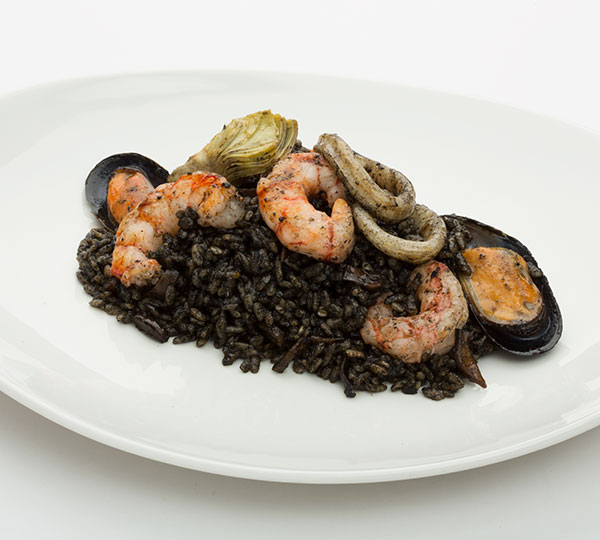 Arroz negro gourmet-Arroz con sofrito y tinta de calamar, aceite de oliva cocinado con gambas, anillas de pota mejillones y alcachofas.